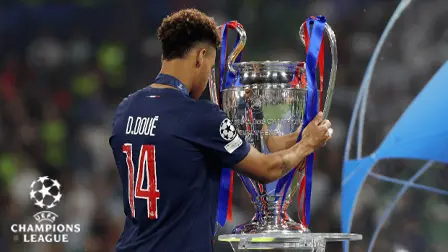 Fotbollsspelare poserar med Champions League-pokalen efter en match i turneringen