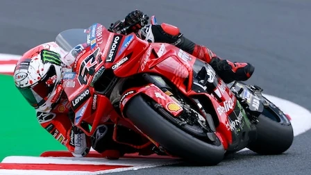 Motorcykelförare lutar sig in i en kurva under fullt tempo i ett MotoGP-lopp