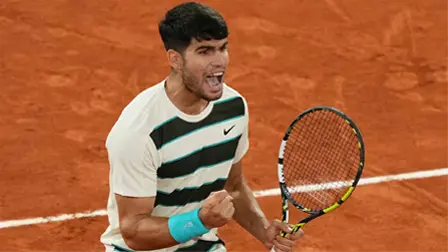 Tennisspelare firar en vunnen poäng med knuten näve på grusbanan